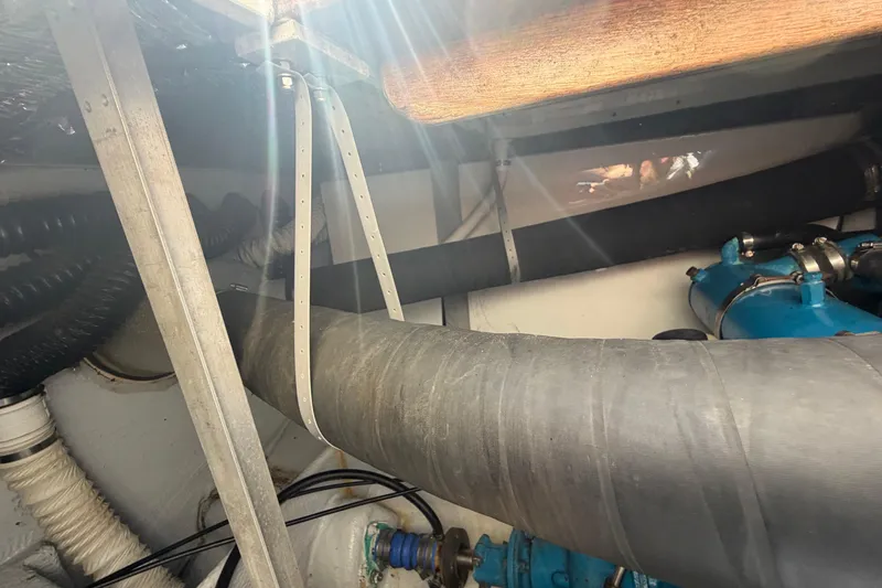 Slide: The Image of Engine compartment of a 1985 Formula 31 Performance Cruiser with visible hoses and metal supports. - 32