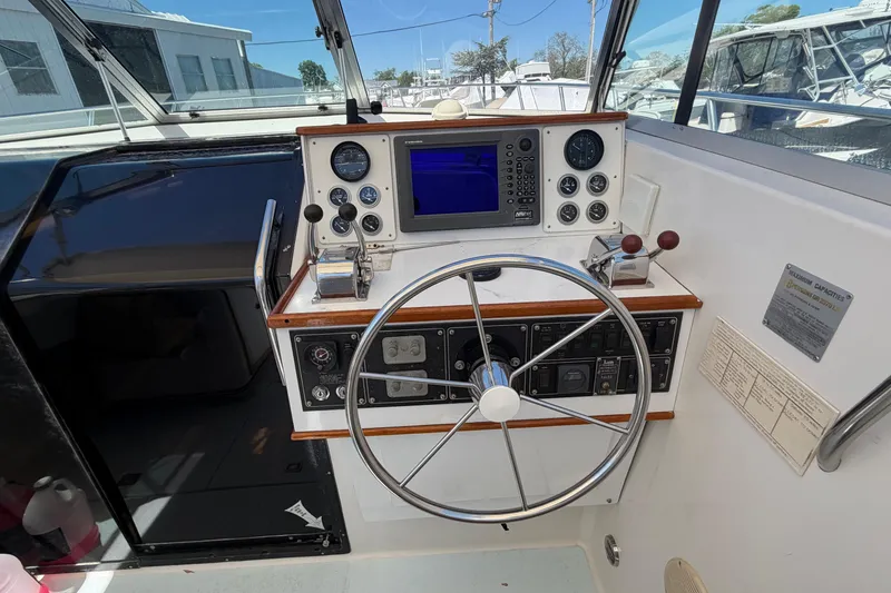 Slide: The Image of 1985 Formula 31 Performance Cruiser helm with steering wheel and navigation instruments. - 47