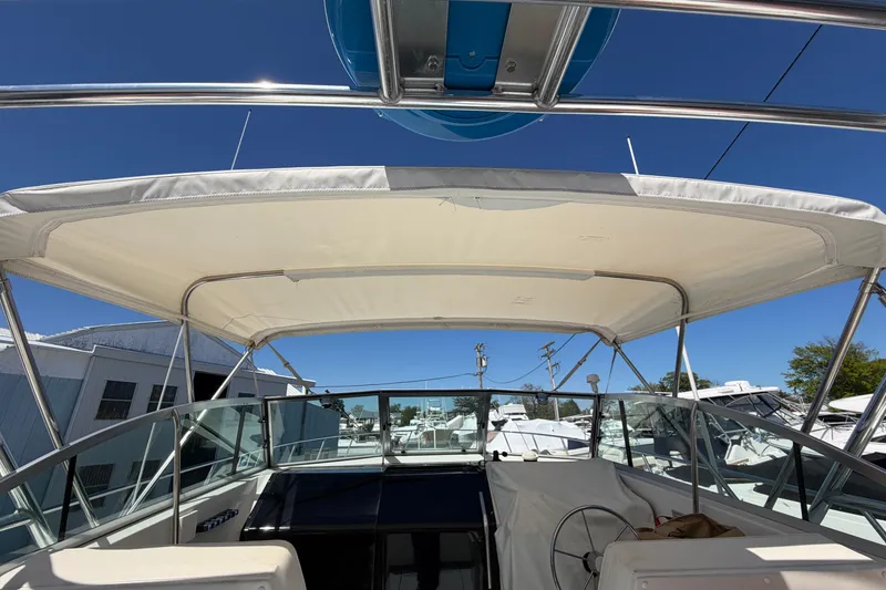Slide: The Image of 1985 Formula 31 Performance Cruiser boat with canopy, docked under clear blue sky. - 48