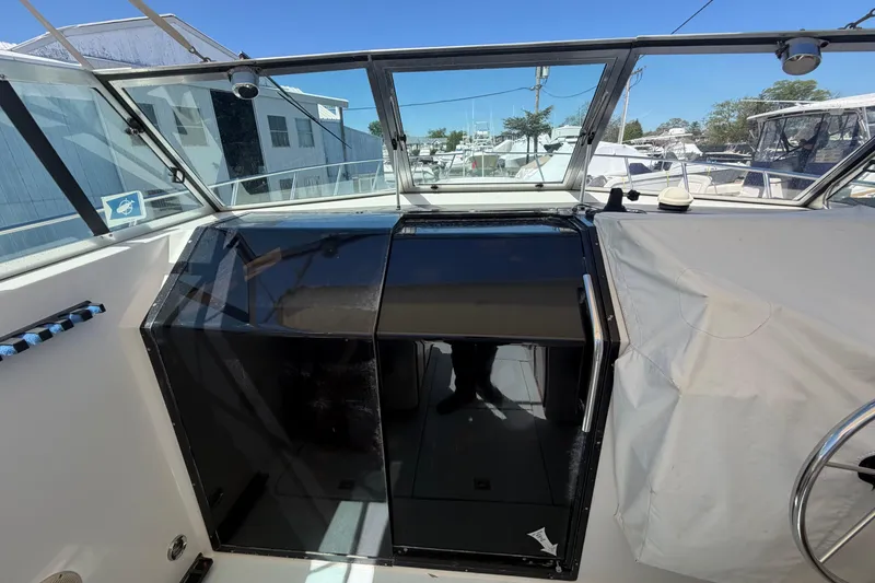 Slide: The Image of 1985 Formula 31 Performance Cruiser cockpit with glass doors and marina view. - 52