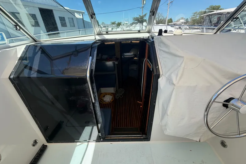 Slide: The Image of 1985 Formula 31 Performance Cruiser cockpit with open cabin door and steering wheel. - 54