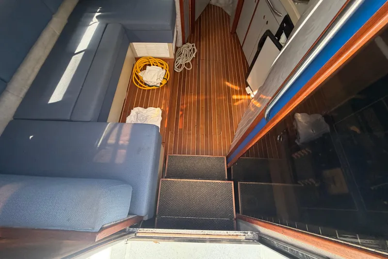 Slide: The Image of Interior of a 1985 Formula 31 Performance Cruiser with blue seating and wooden flooring. - 58