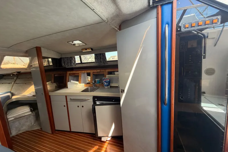 Slide: The Image of 1985 Formula 31 Performance Cruiser interior with kitchenette and wood accents. - 59