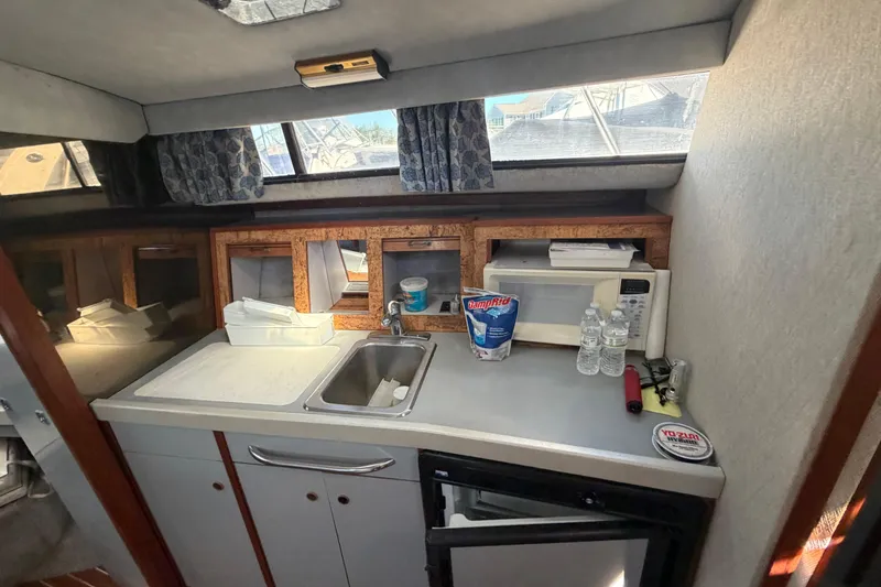 Slide: The Image of 1985 Formula 31 Performance Cruiser interior kitchen with sink, microwave, and storage. - 62
