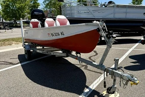 The Image of 1958 Jon Boat Aluminum model on trailer, parked in a lot, with visible registration. - 1
