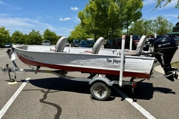 Slide: The Image of 1958 Jon Boat Aluminum model on trailer, parked in sunny lot with trees. - 4