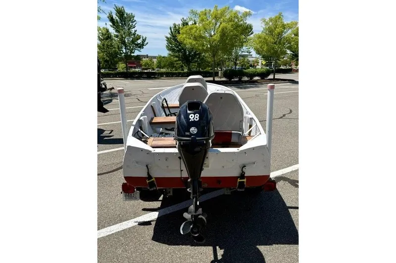 Slide: The Image of 1958 Jon Boat Aluminum with outboard motor in a parking lot. - 5