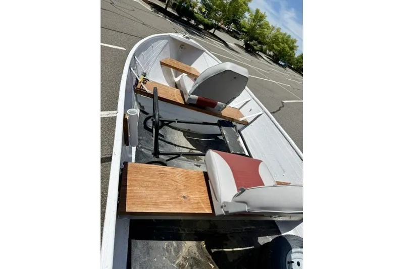 Slide: The Image of 1958 Jon Boat Aluminum model with wooden seats in a parking lot. - 8