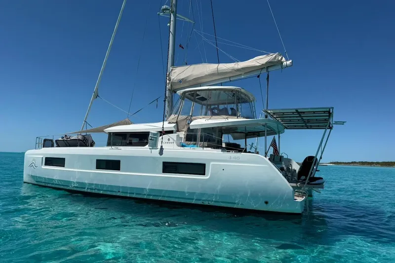 The Image of 2022 Lagoon 46 catamaran sailing on clear turquoise waters under a bright blue sky. - 1