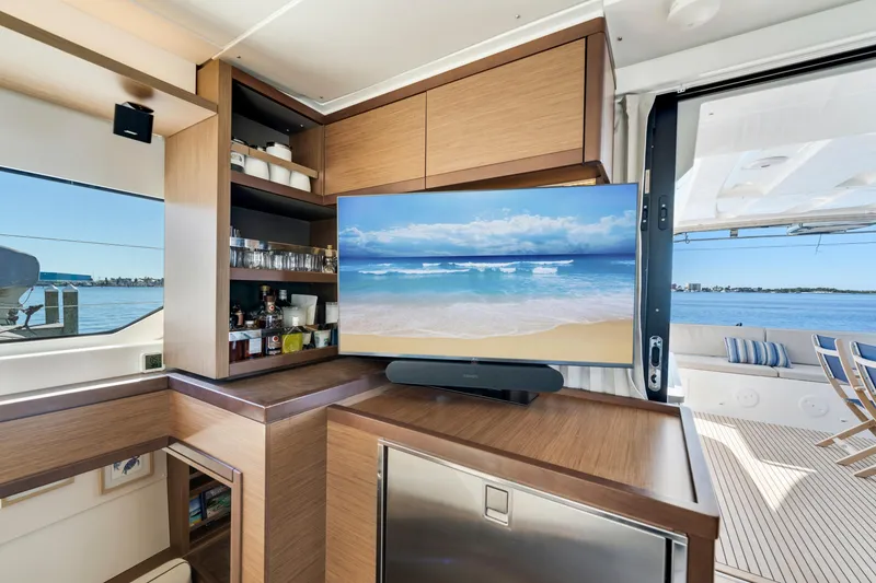 Slide: The Image of Interior of 2022 Lagoon 46 yacht with TV, wooden cabinetry, and ocean view. - 16