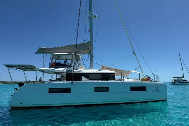 Slide: The Image of 2022 Lagoon 46 catamaran sailing on clear blue water under a sunny sky. - 2