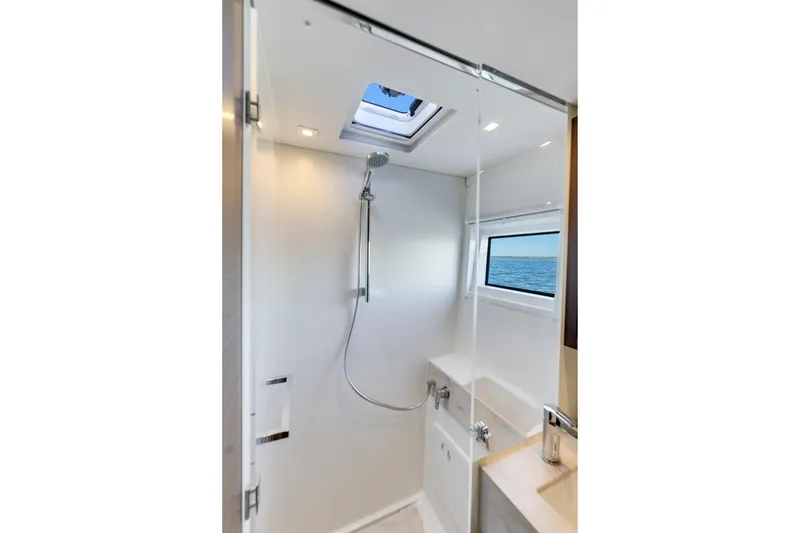 Slide: The Image of Modern shower area in 2022 Lagoon 46 yacht with ocean view window. - 28