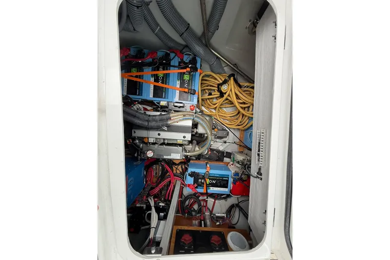 Slide: The Image of Electrical compartment of a 2022 Lagoon 46 yacht, featuring batteries and wiring. - 35