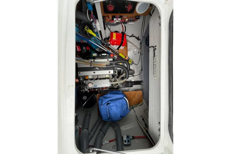 Slide: The Image of Engine compartment of a 2022 Lagoon 46 yacht, featuring mechanical components and storage items. - 39