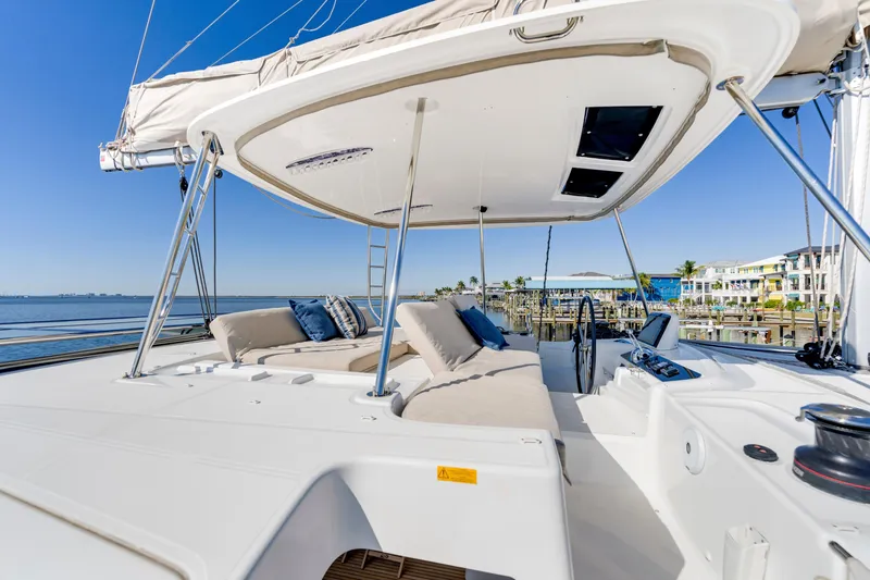 Slide: The Image of Luxurious 2022 Lagoon 46 catamaran with spacious deck and comfortable seating, docked by the waterfront. - 8