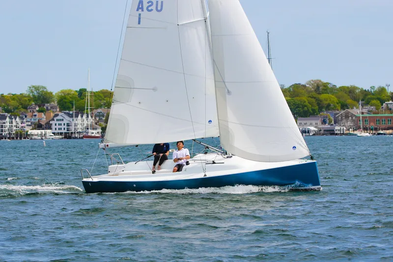Slide: The Image of J Boats J/7 2026 sailboat on calm waters near coastal town. - 10