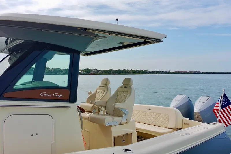 Slide: The Image of 2024 Chris-Craft Catalina 30 boat with luxurious seating, docked by a serene waterfront. - 13