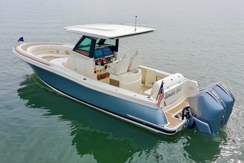 Slide: The Image of 2024 Chris-Craft Catalina 30 boat on calm water, featuring dual outboard engines. - 35