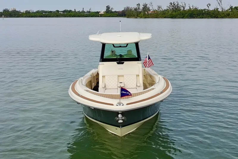 Slide: The Image of 2024 Chris-Craft Catalina 30 boat on calm water, featuring elegant design and American flag. - 43