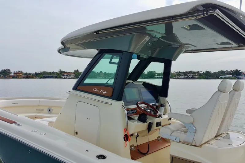 Slide: The Image of 2024 Chris-Craft Catalina 30 boat interior with helm and seating on calm water. - 7