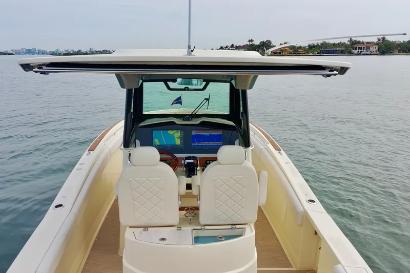 Slide: The Image of 2024 Chris-Craft Catalina 30 boat interior with helm and navigation screens on calm water. - 8