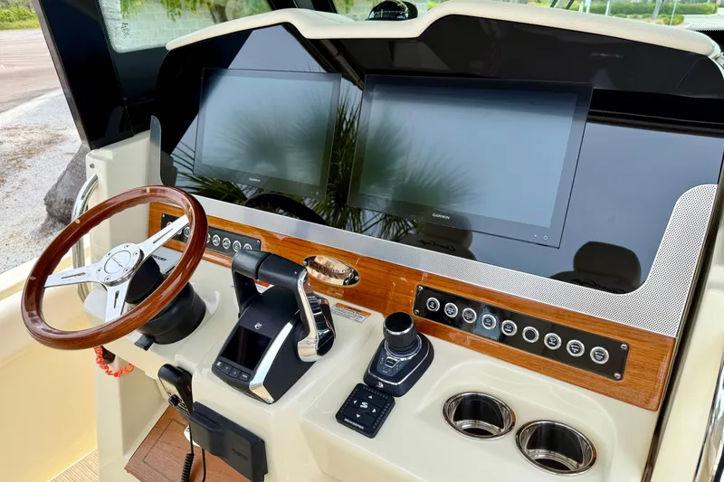 Slide: The Image of 2024 Chris-Craft Catalina 30 helm with dual screens, wooden steering wheel, and control panel. - 9