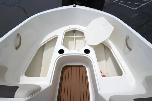 Slide: The Image of 2019 Bayliner Element 160 boat interior with storage compartments and wood-textured flooring. - 10
