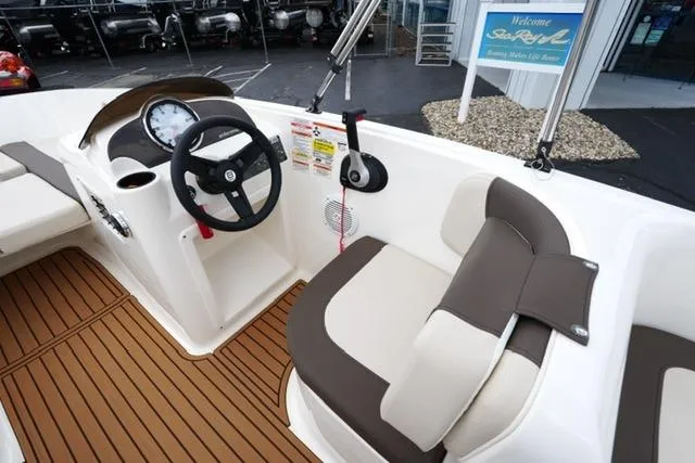 Slide: The Image of 2019 Bayliner Element 160 boat interior with steering wheel and cushioned seating. - 12
