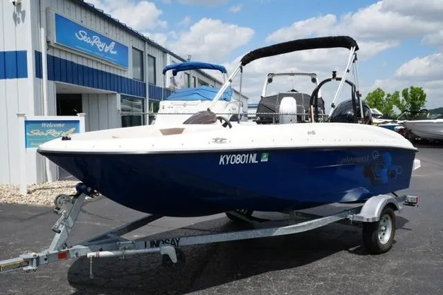 Slide: The Image of 2019 Bayliner Element 160 boat on trailer, parked outside dealership under blue sky. - 2