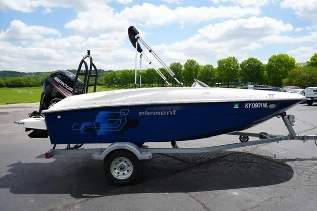 Slide: The Image of 2019 Bayliner Element 160 boat on trailer, parked outdoors under a cloudy sky. - 4
