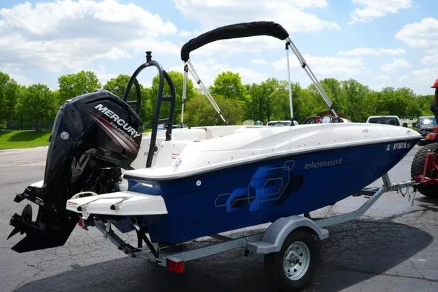 Slide: The Image of 2019 Bayliner Element 160 boat with Mercury outboard motor on a trailer, parked outdoors. - 5