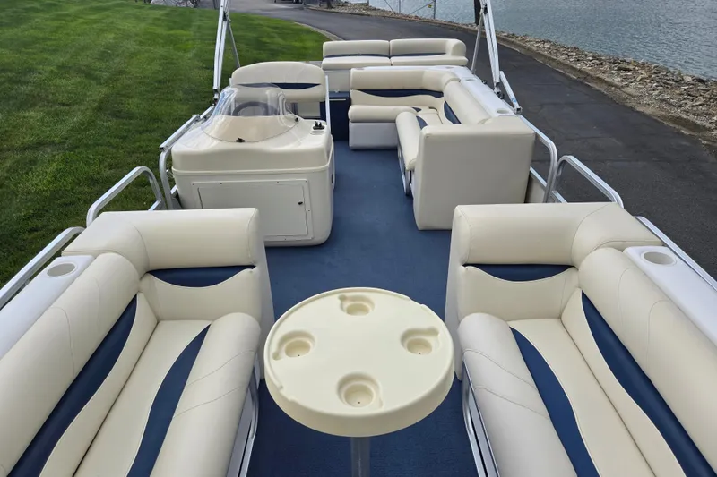 Slide: The Image of 2004 Odyssey Pontoons 2302 Millennium with spacious seating and cup holders on a blue carpeted deck. - 11