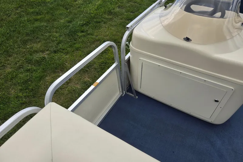 Slide: The Image of 2004 Odyssey Pontoons 2302 Millennium boat interior with beige seating and blue carpet. - 13