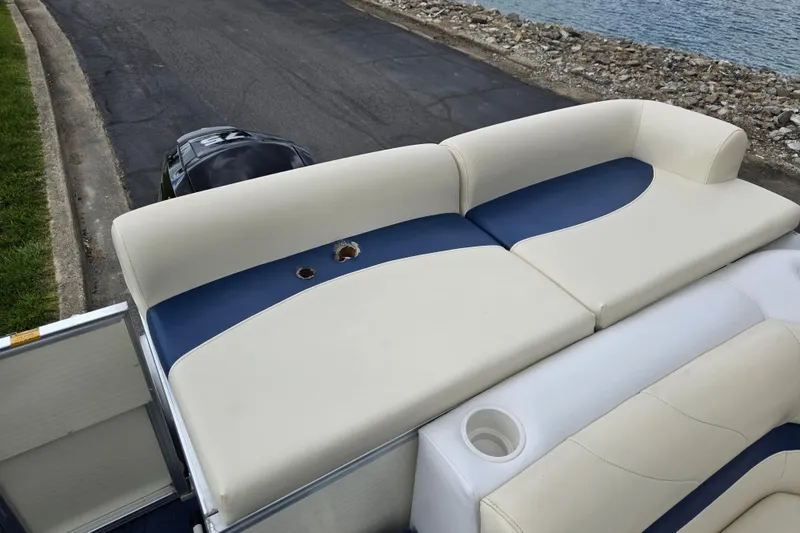 Slide: The Image of 2004 Odyssey Pontoons 2302 Millennium boat seating with blue and white upholstery, near water. - 16