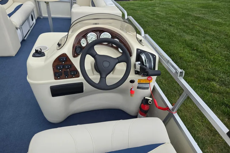 Slide: The Image of 2004 Odyssey Pontoons 2302 Millennium boat helm with steering wheel and control panel. - 21