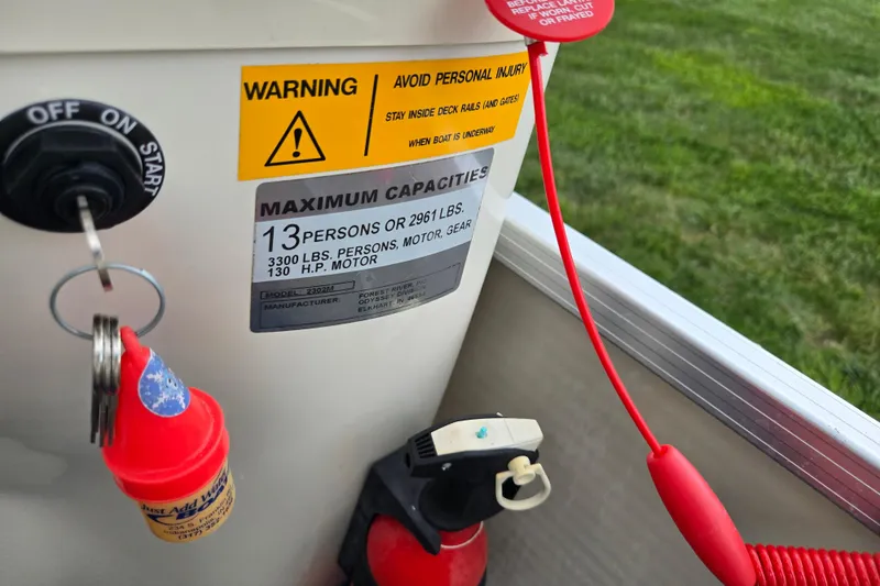Slide: The Image of 2004 Odyssey Pontoons 2302 Millennium capacity warning label with ignition key and safety instructions. - 22