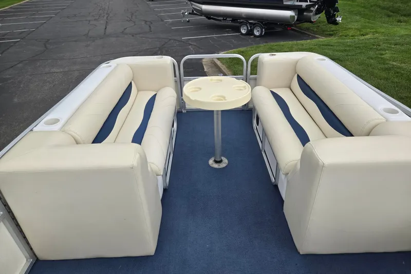 Slide: The Image of 2004 Odyssey Pontoons 2302 Millennium interior with beige seating and a central table. - 24
