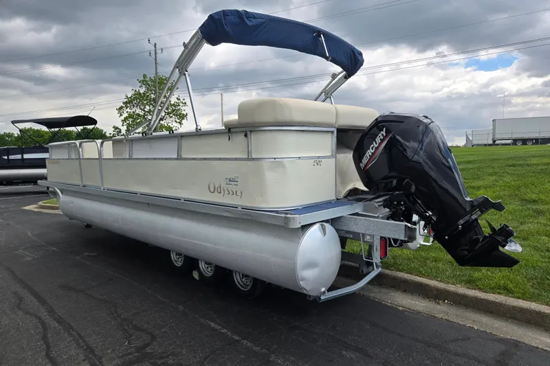 Slide: The Image of 2004 Odyssey Pontoons 2302 Millennium boat with Mercury outboard motor on a paved surface. - 3