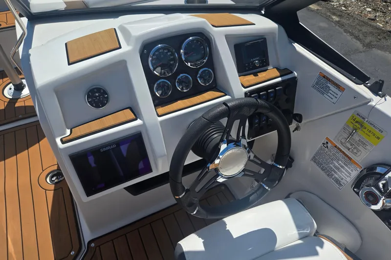 Slide: The Image of 2023 Starcraft SVX 230 IO boat dashboard with steering wheel and control gauges. - 12
