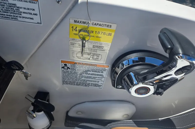 Slide: The Image of Control panel of 2023 Starcraft SVX 230 IO boat with capacity and safety labels. - 13