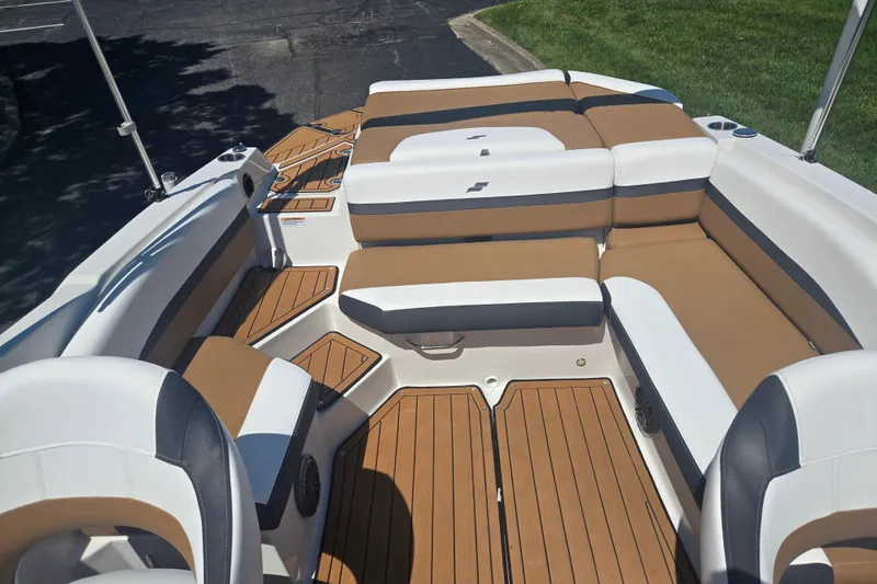 Slide: The Image of 2023 Starcraft SVX 230 IO boat interior with tan and white seating, wood-style flooring. - 23