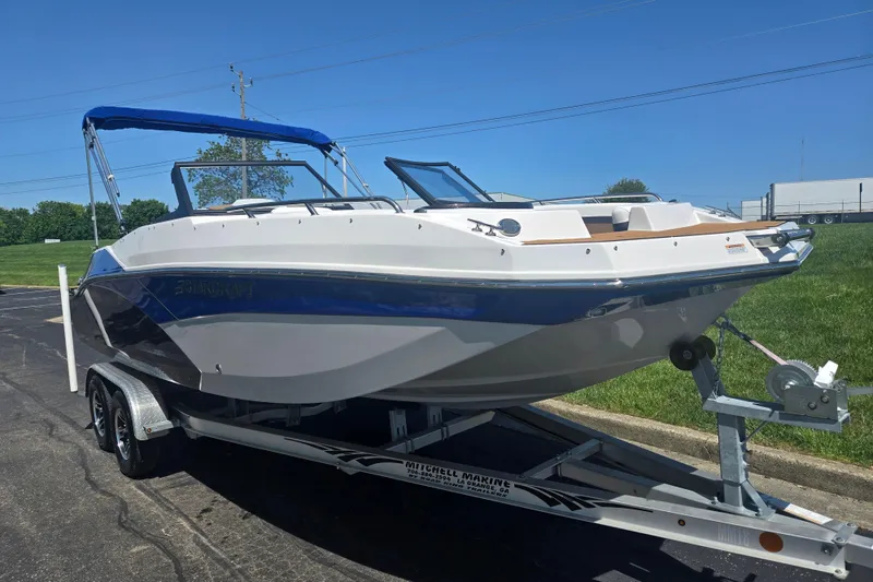 Slide: The Image of 2023 Starcraft SVX 230 IO boat on trailer, featuring sleek design and blue canopy. - 5