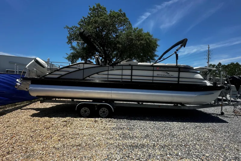 The Image of 2019 Bennington QX 25 Stern Lounge pontoon boat on trailer, parked outdoors. - 1