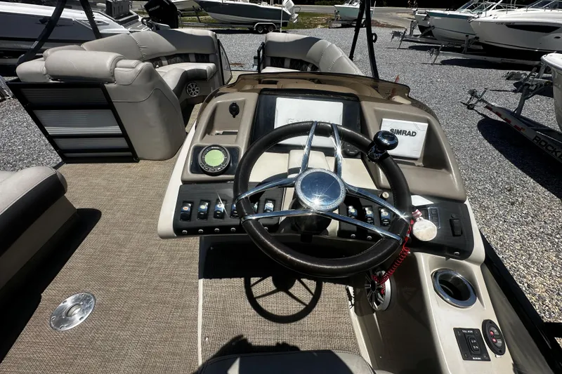 Slide: The Image of 2019 Bennington QX 25 Stern Lounge boat dashboard with steering wheel and controls. - 8
