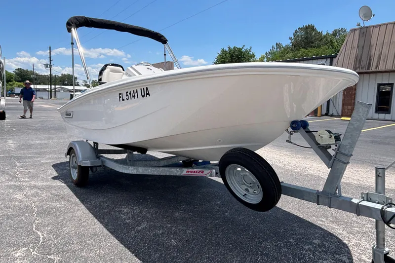 Slide: The Image of 2025 Boston Whaler 130 Super Sport boat on trailer in parking lot. - 12
