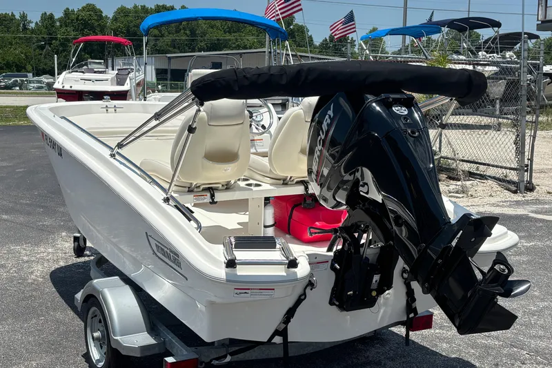 Slide: The Image of 2025 Boston Whaler 130 Super Sport boat with Mercury engine on trailer, outdoors. - 14