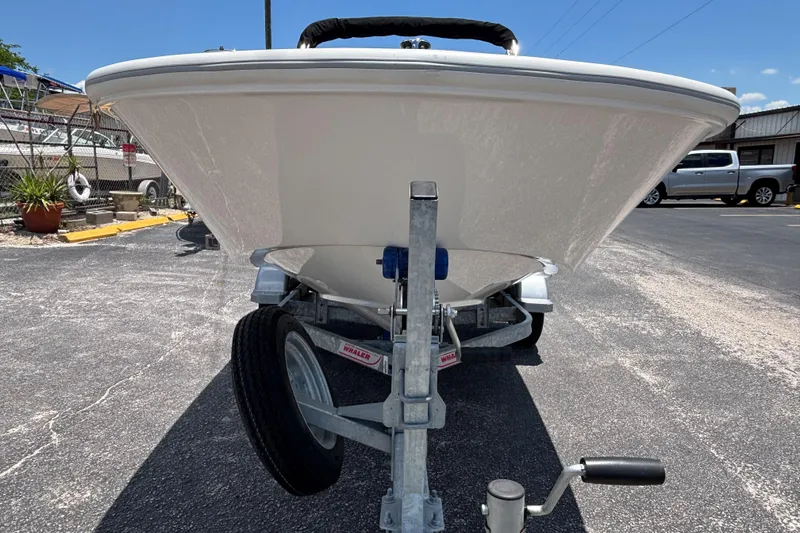 Slide: The Image of 2025 Boston Whaler 130 Super Sport boat on trailer, front view in parking lot. - 18