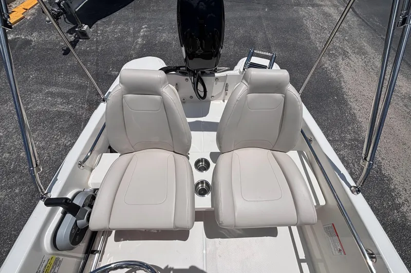 Slide: The Image of 2025 Boston Whaler 130 Super Sport boat interior with dual white seats and steering console. - 26