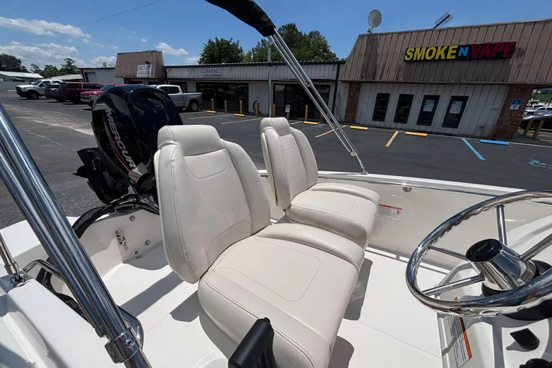 Slide: The Image of 2025 Boston Whaler 130 Super Sport boat interior with white seating and steering wheel. - 27