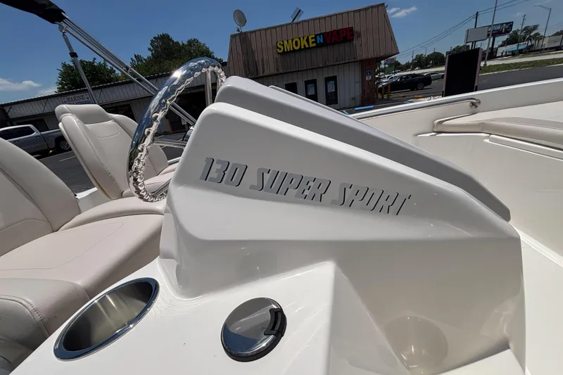 Slide: The Image of 2025 Boston Whaler 130 Super Sport boat interior with steering wheel and seating. - 28
